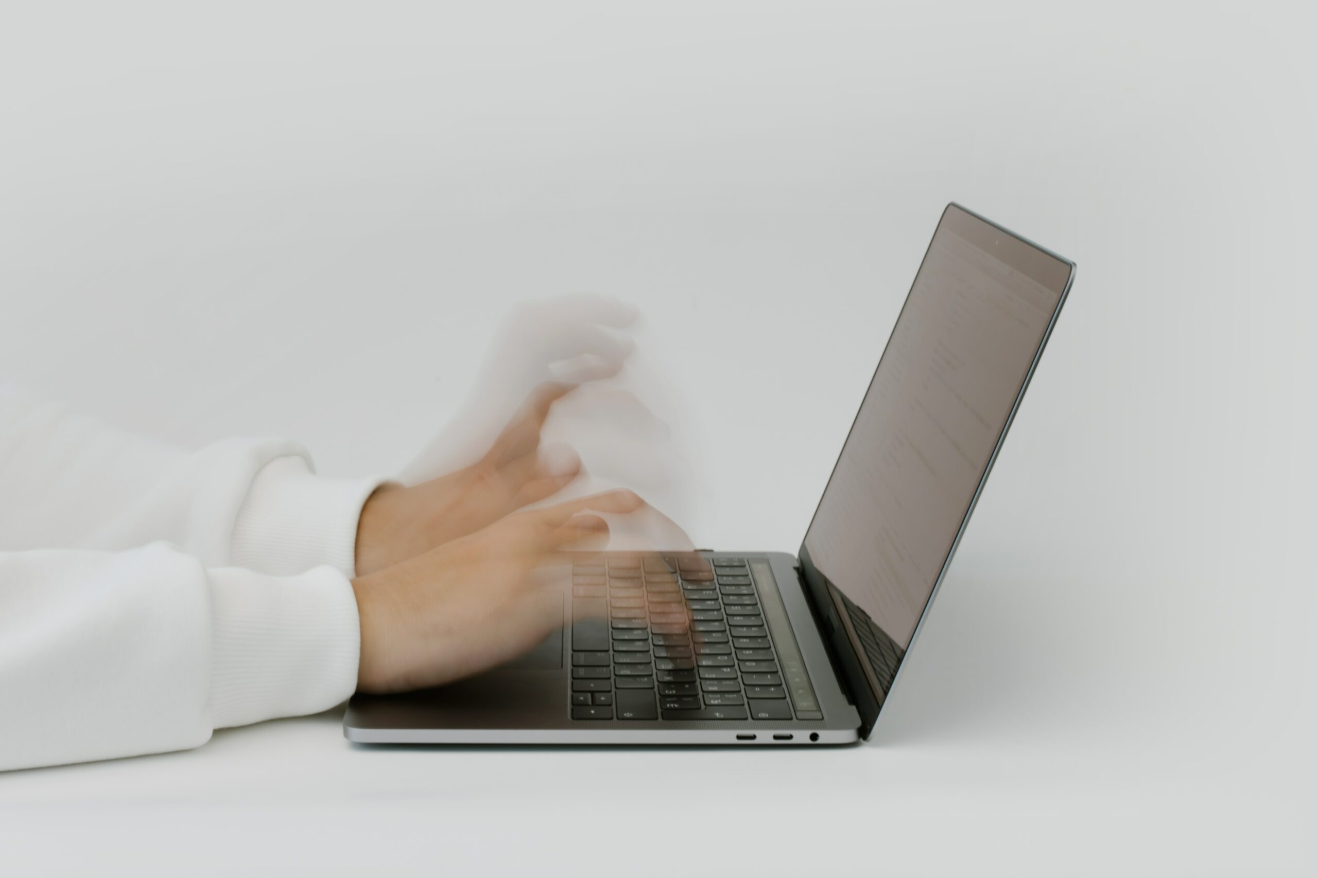 Mains tapant à toute vitesse sur un clavier d'ordinateur portable