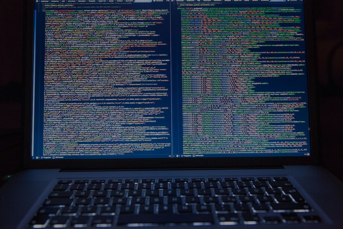 traduction et sécurité des données : image représentant un écran d'ordinateur qui affiche deux colonnes de code dans une pièce sombre
